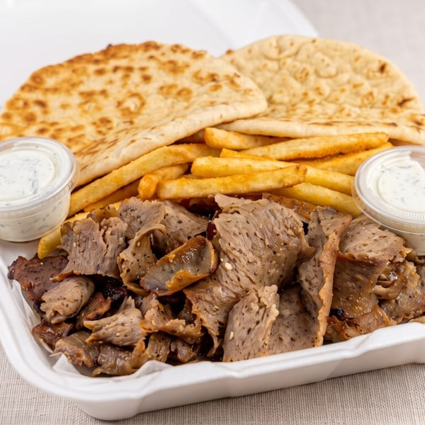 Gyro meat platter with fries, pita bread, and two cups of tzatziki sauce in a takeout container.